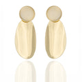  Gold-tone sculptural drop earrings with elongated silhouette. Bold, reflective, and architecturally expressive by Dramma®.
