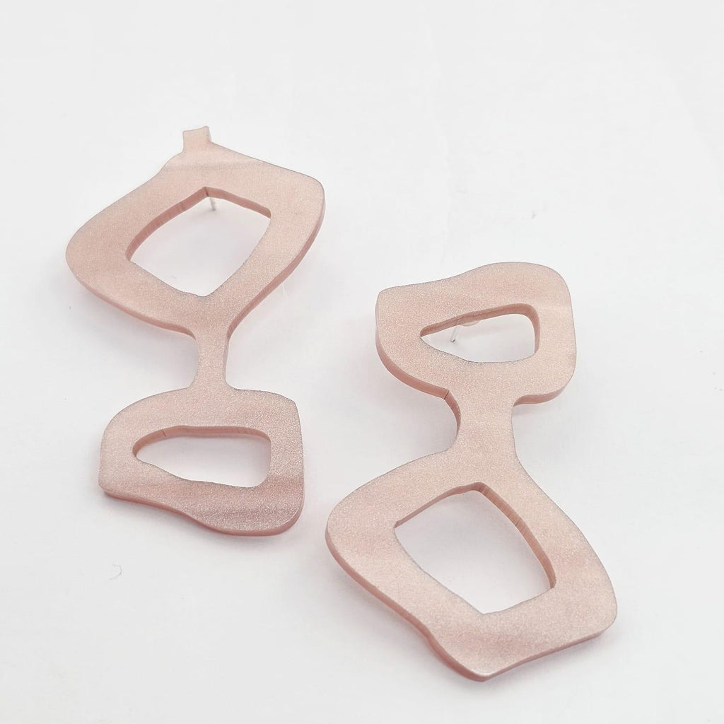Asymmetric acrylic earrings in pearl rose. Lightweight, graphic, and hypoallergenic — handmade wearable art by Dramma®.
