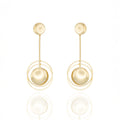 Gold dangle earrings with floating sphere and geometric balance. Lightweight, sculptural, and hypoallergenic — modern elegance by Dramma®.
