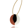 Reversible acrylic necklace in amber, red, ivory, and black. Lightweight, sculptural, and handmade — bold geometric pendant by Dramma®.


